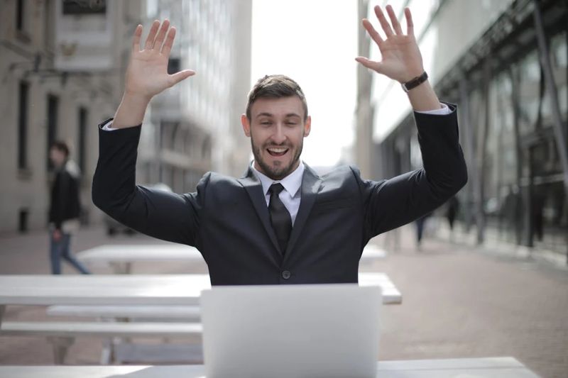 A Man Celebrating in Front of His Laptop